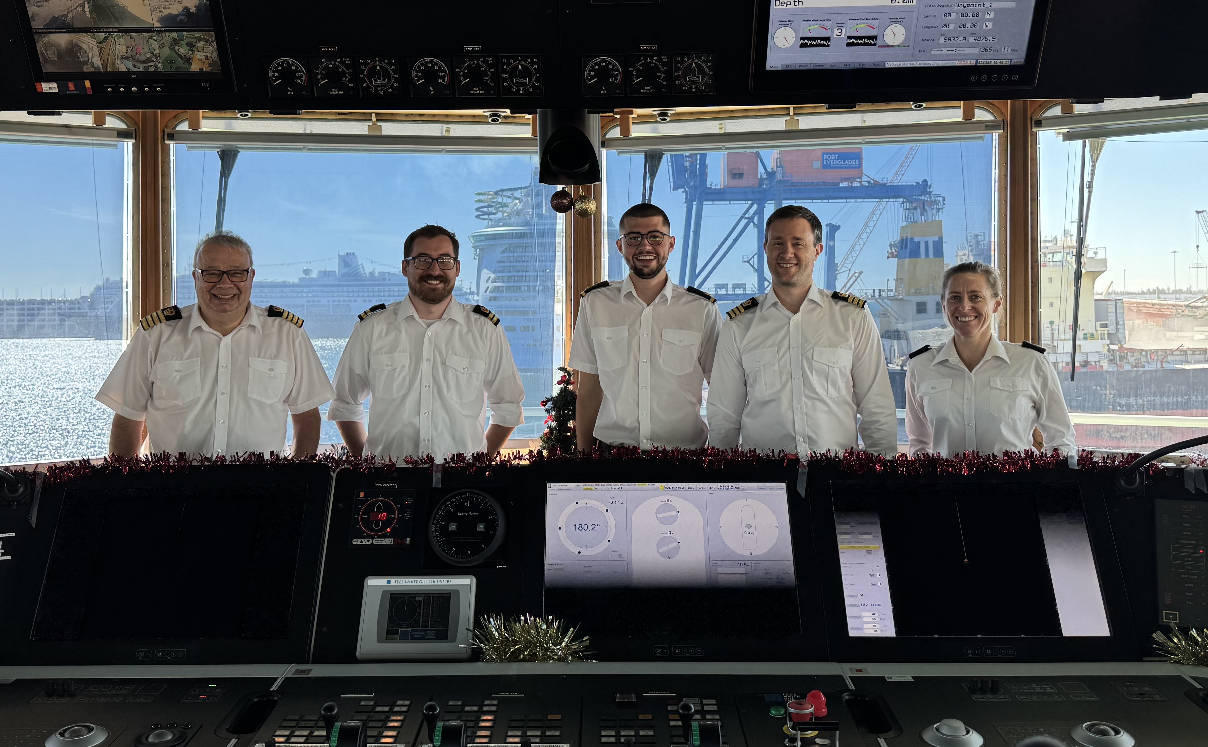 The RRS Discovery’s officers on the tinsel clad bridge (complete with Christmas tree) before setting sail for their Christmas passage from Port Everglades, Florida. 