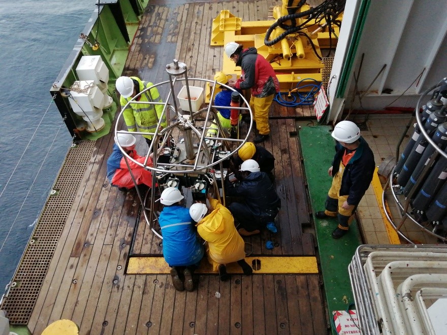 Scientists working on deck to remove samples of the seabed from a corer