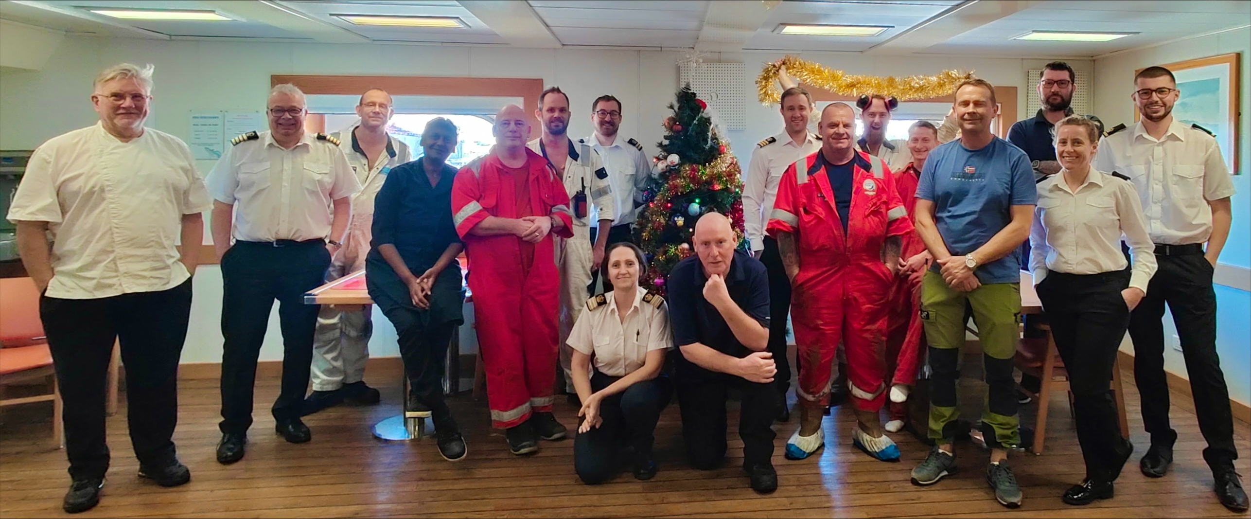 The crew onboard the RRS Discovery gathering around their Christmas tree in the mess.